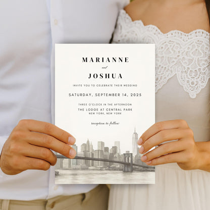 Best hand-illustrated wedding invitation template held by couple featuring city skyline and elegant text design