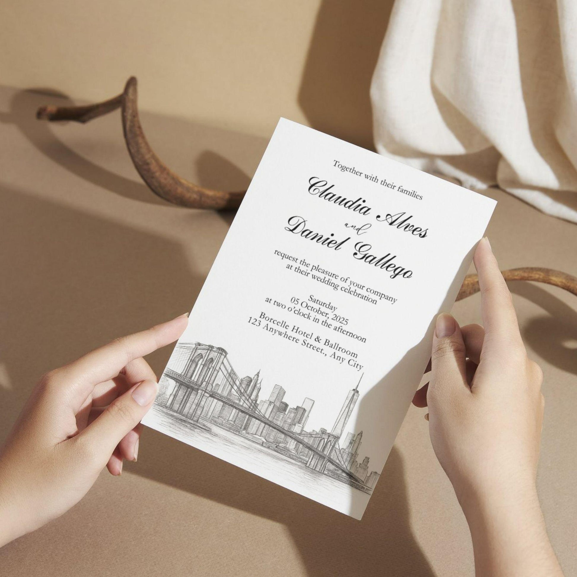 Best hand-illustrated wedding invitation template held by hands featuring city skyline and elegant text design