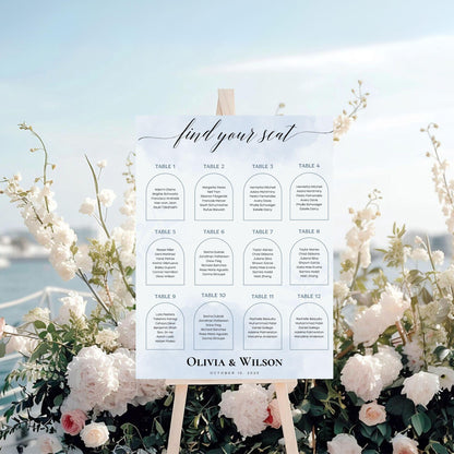 Elegant wedding seating chart template by ProCardist displayed on easel with floral decor and ocean background